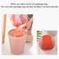 Removable plastic trash bin with lid and pink lining, bag being pulled out