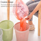 Removable plastic trash bin with lid, pink bin with bag being inserted, green bin nearby