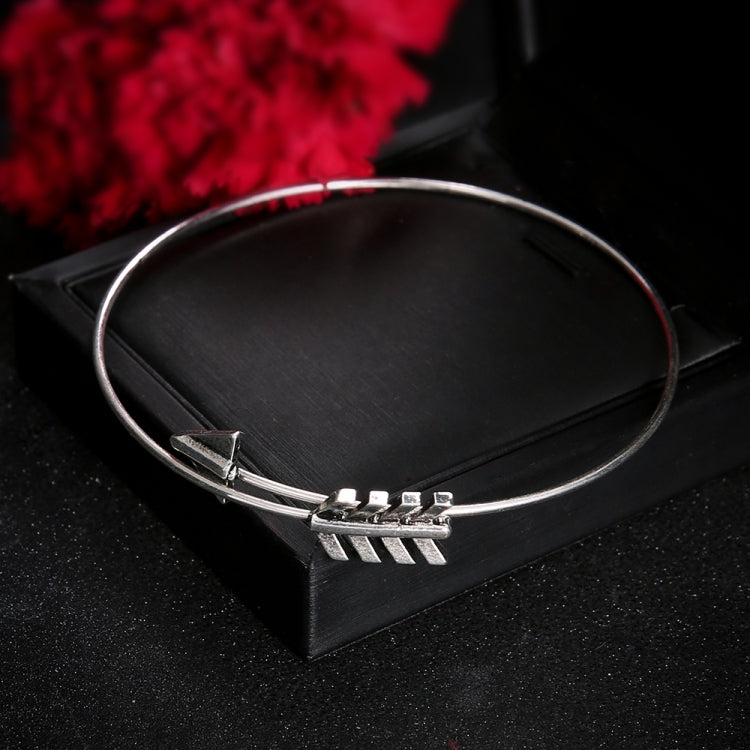 Silver-toned bangle bracelet with arrow bar and arrowhead charm design
