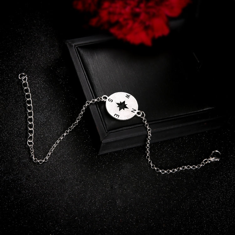 Silver-toned compass charm bracelet with chain links and lobster clasp