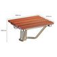 Wall-mounted shower chair with brown slat seat and curved chrome support legs