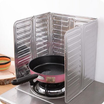 Stainless steel cooktop oil shield with folding panels around a frying pan