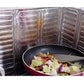 Stainless steel cooktop oil shield containing splatter around a frying pan