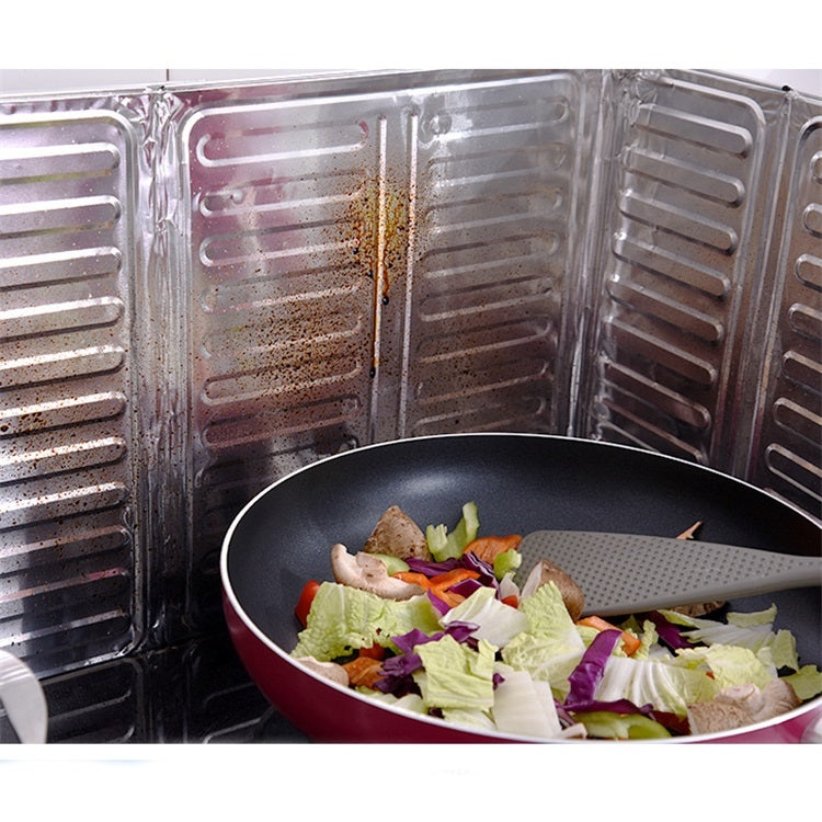 Stainless steel cooktop oil shield containing splatter around a frying pan
