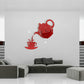 Red teapot-shaped acrylic wall clock with cup decal and red hands on a wall