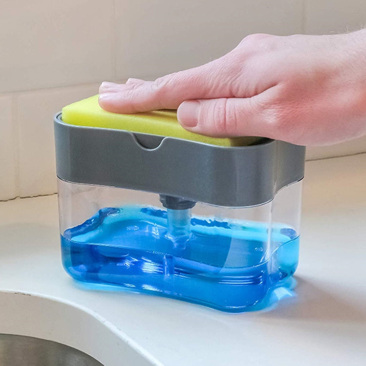 Gray soap dispenser with silver press cap and clear tank; blue liquid flowing from nozzle