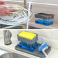 Gray press soap dispenser with clear top and blue base, with sponge and scrub brush