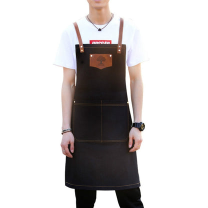 Black hairdressing apron with brown leather straps, front pocket and stitched panels