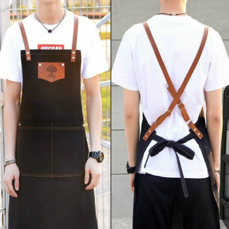 Back of black hairdressing apron with crisscross brown straps and waist tie
