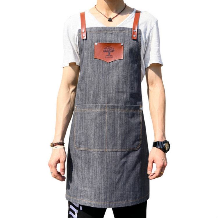 Gray denim hairdressing apron with brown leather straps and front logo patch