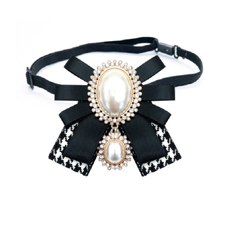 Black belt accessory with patterned ribbon bow brooch and oval pearl centers, rhinestone trim