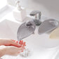 Beige toddler faucet extender installed on bathroom sink spout, hands washing