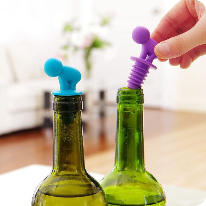 Blue and purple cartoon silicone spiral wine stoppers on green glass bottles