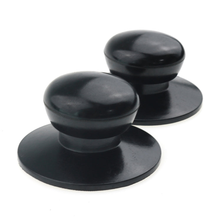 Two black pot lid handle caps, round bases with dome tops