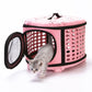 Pink pet carrier with vented metal side panel, mesh window, and pet inside; top handle.