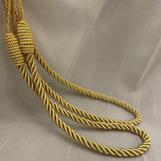 Hand-wound curtain rope tieback, braided gold-yellow cord looped for curtain holdback