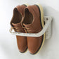 Wall hanging slipper storage rack with suction mount holding brown slippers