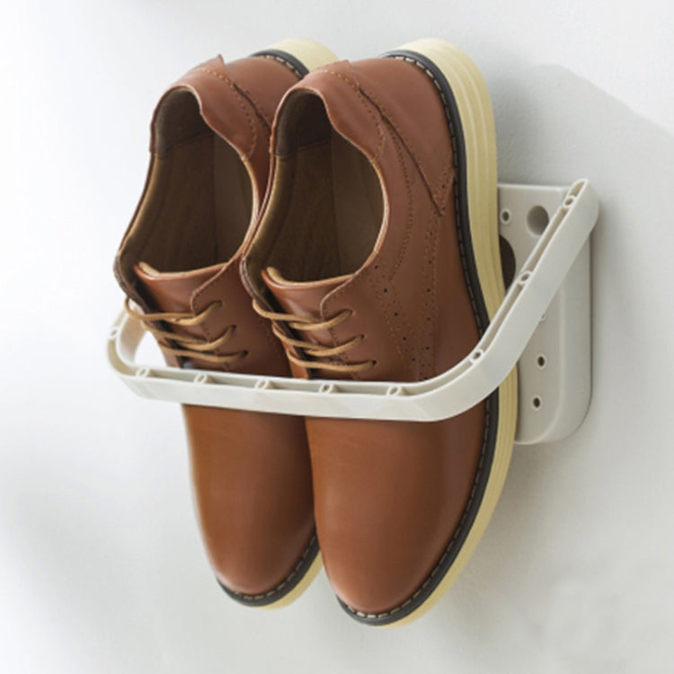 Wall hanging slipper storage rack with suction mount holding brown slippers