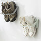 Wall hanging slipper storage rack with suction mount holding dark and white sneakers