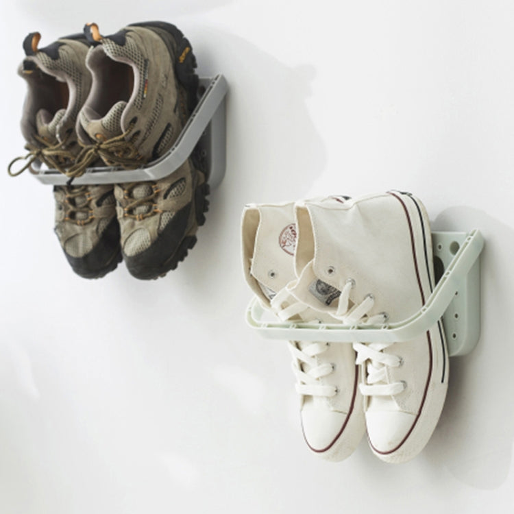 Wall hanging slipper storage rack with suction mount holding dark and white sneakers