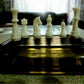Pale chess pieces on a board in a play setup