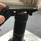 Black corkscrew opener gripping a bottle cork, with red tip visible