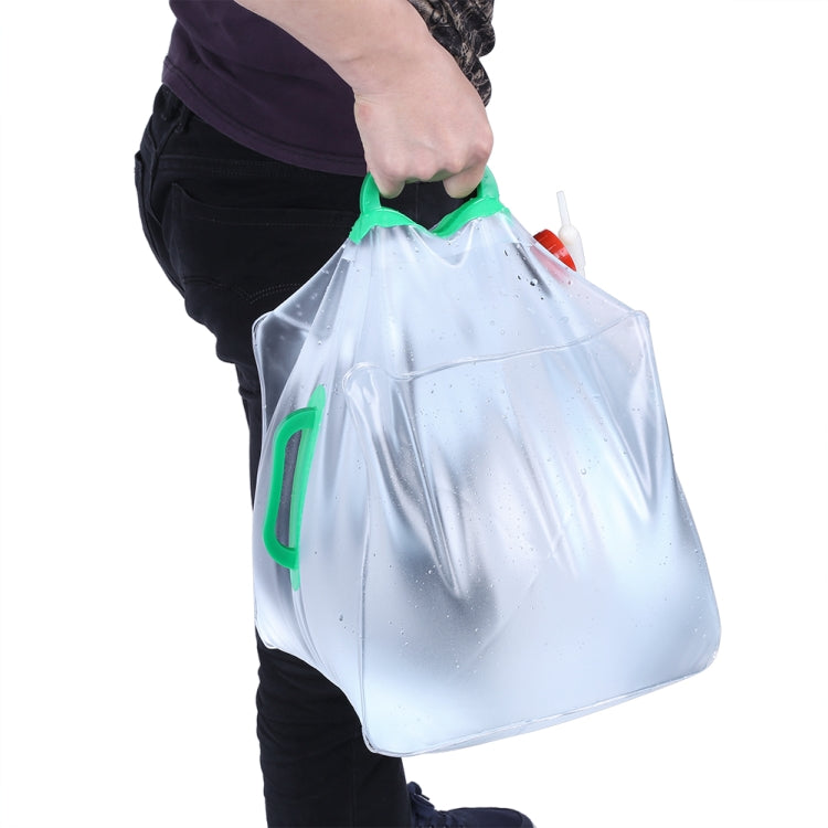 Foldable transparent PVC drinking bag held by green handle with red spout on side.