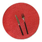 Round woven placemat in red with speckled texture and cutlery centerpiece