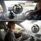 Suction-mounted black navigation compass on car dashboard near steering wheel