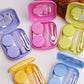 Set of mini square contact lens cases in pink, purple, and yellow with mirrors