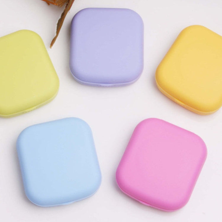 Mini square contact lens cases in light blue, lilac, yellow, and pink—closed