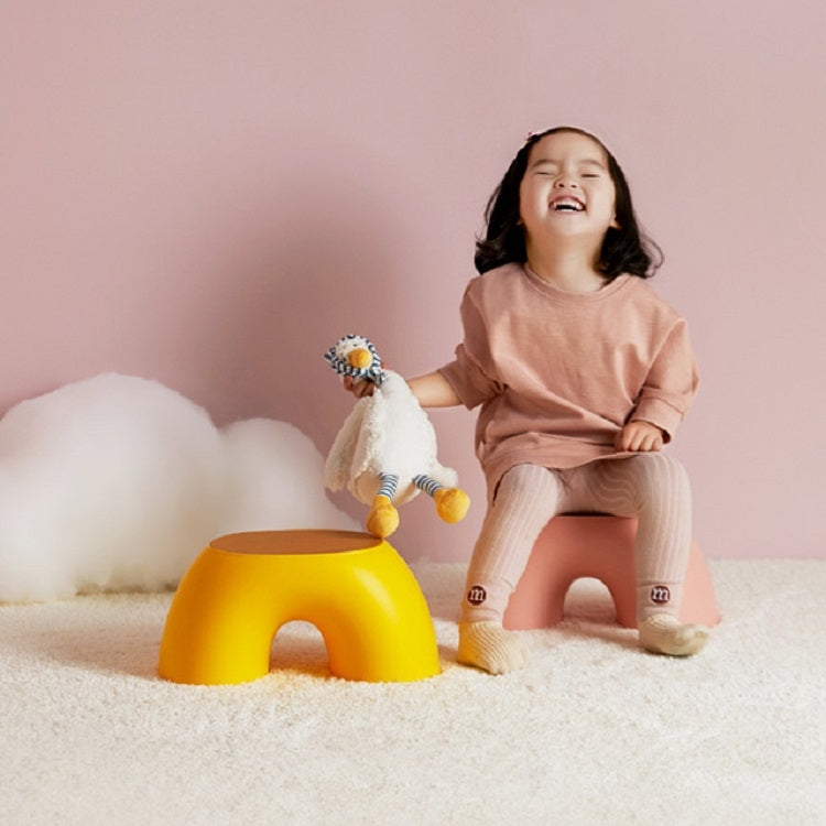 Yellow round kids stool with curved base and front cutout; flat top seat.