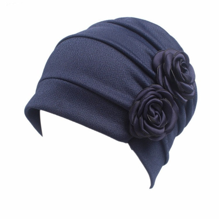 Navy blue chemo cap with pleated crown and large fabric rosette flower