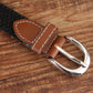 Narrow elastic canvas weave belt with dark brown braid, brown leather end strap, silver buckle.