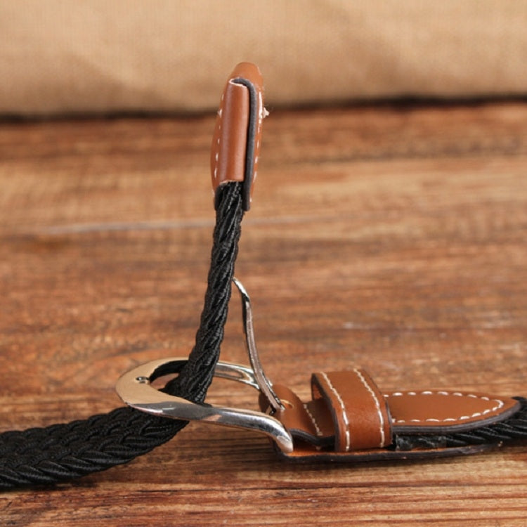 Narrow elastic canvas weave belt with black braided webbing, brown leather ends, silver buckle.