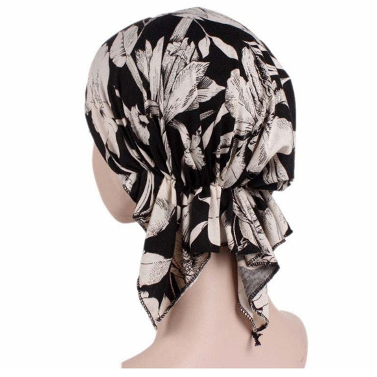 Black and white leafy feather-print stretch turban cap with long side tail