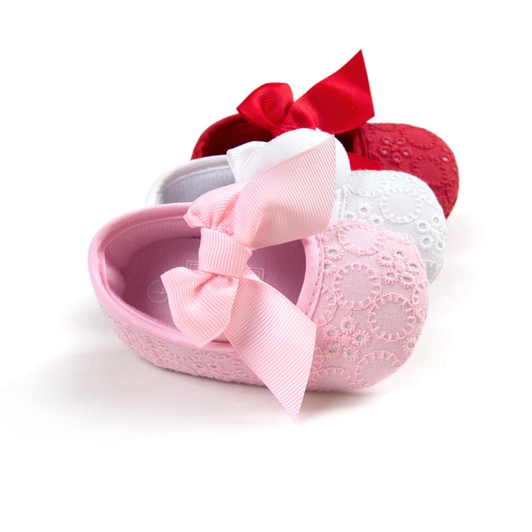 Toddler princess shoes in pink with red accent bow and textured fabric uppers