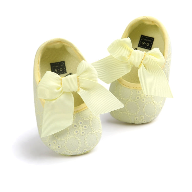 Toddler princess shoes in pale yellow with large bow straps and textured uppers