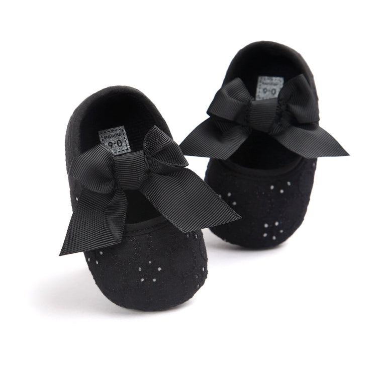 Toddler black slip-on shoes with big black bow and perforated textured fabric
