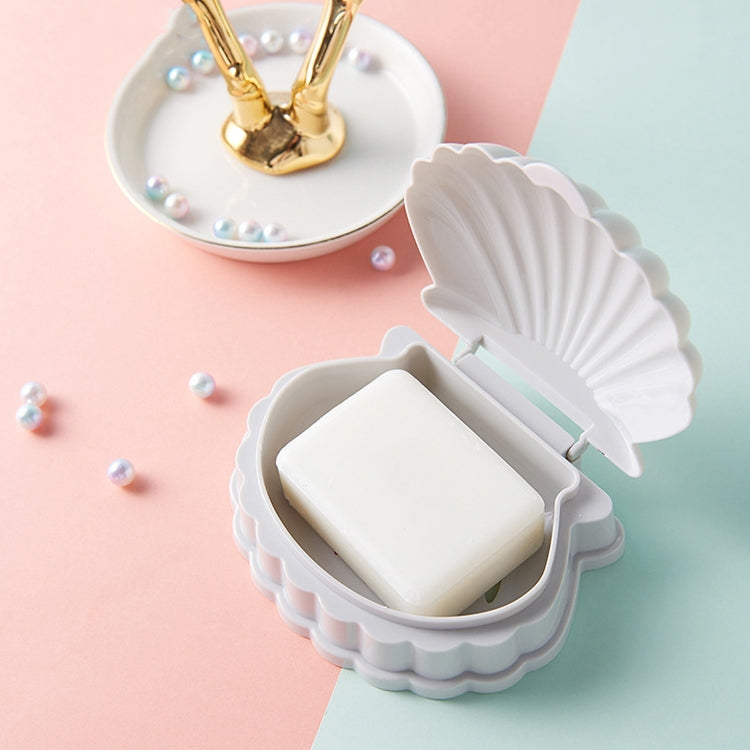Gray seashell soap dish with flip lid holding a white bar of soap