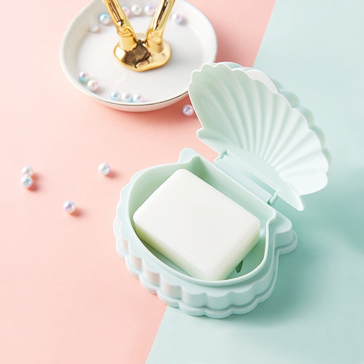 Light green seashell soap box with flip lid and bar soap, with drain slots