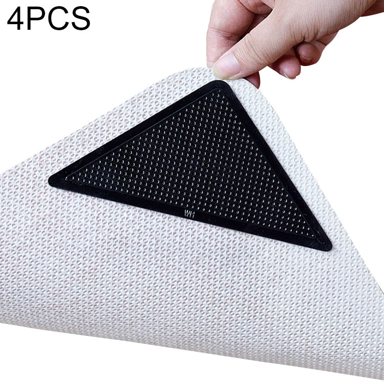 Triangular black non-slip bath mat sticker with textured grip and backing sheet.
