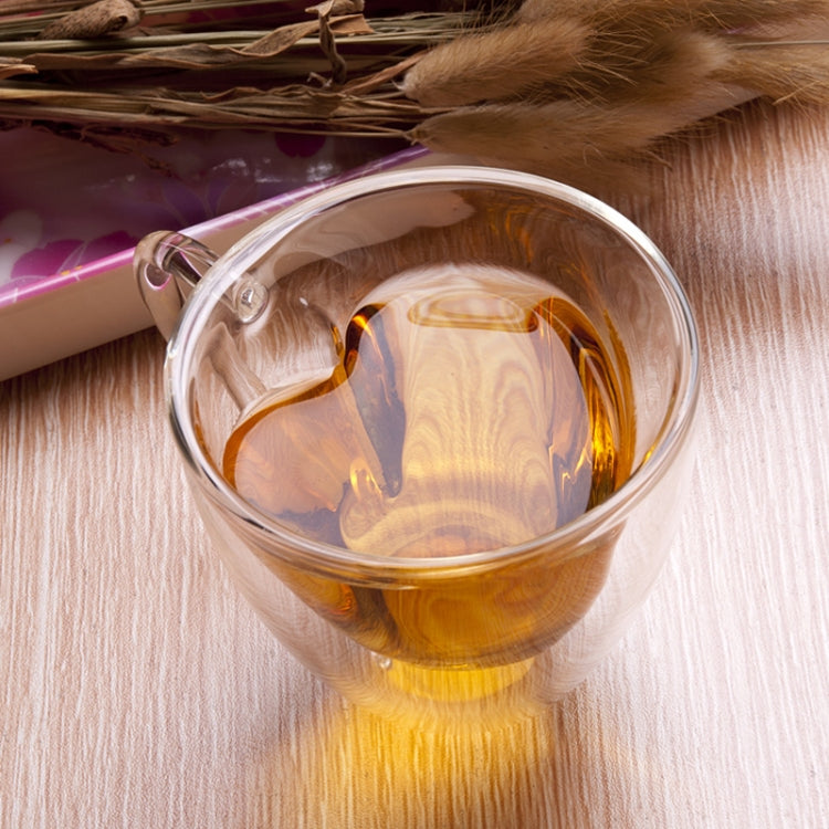 Heart-shaped double-wall glass mug with amber tea filling and transparent sides