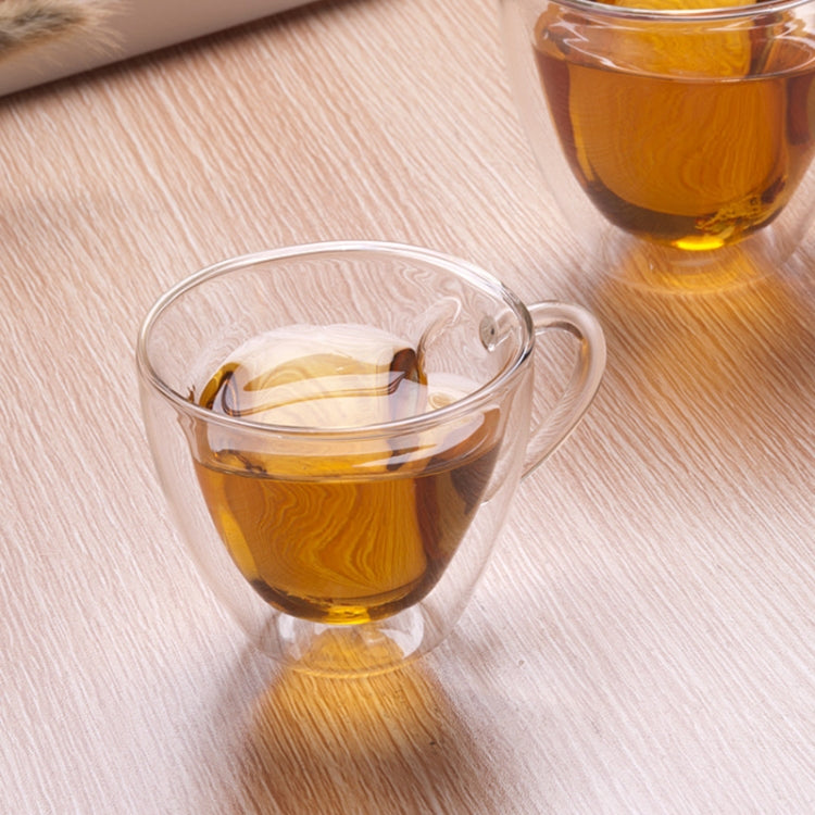 Heart-shaped double-wall glass mug with amber tea and side handle, transparent cup