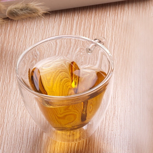 Heart-shaped double-wall glass mug with amber tea, rounded rim and handle