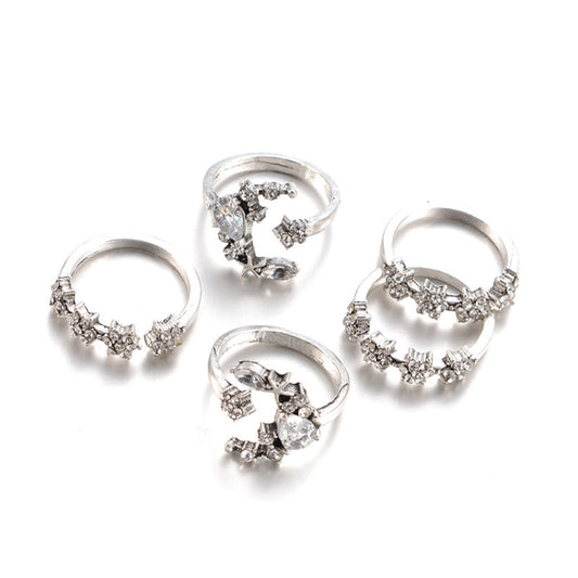 Set of five silver-tone adjustable rings with star and moon designs, front view