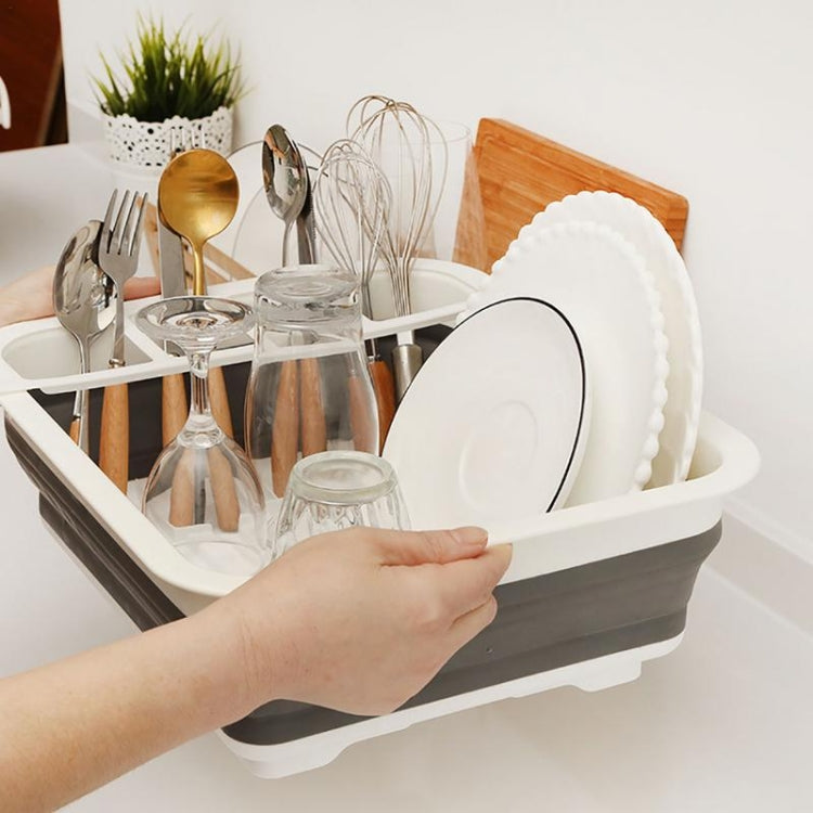 Dish rack holding plates and utensils; foldable white rack system over gray base