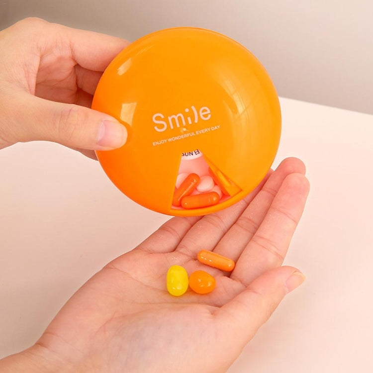 Orange 7-day rotating pill container held open with pills inside