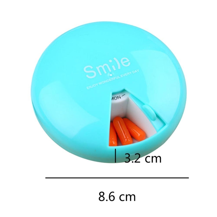 Blue 7-day rotating pill container with open compartment and orange capsules