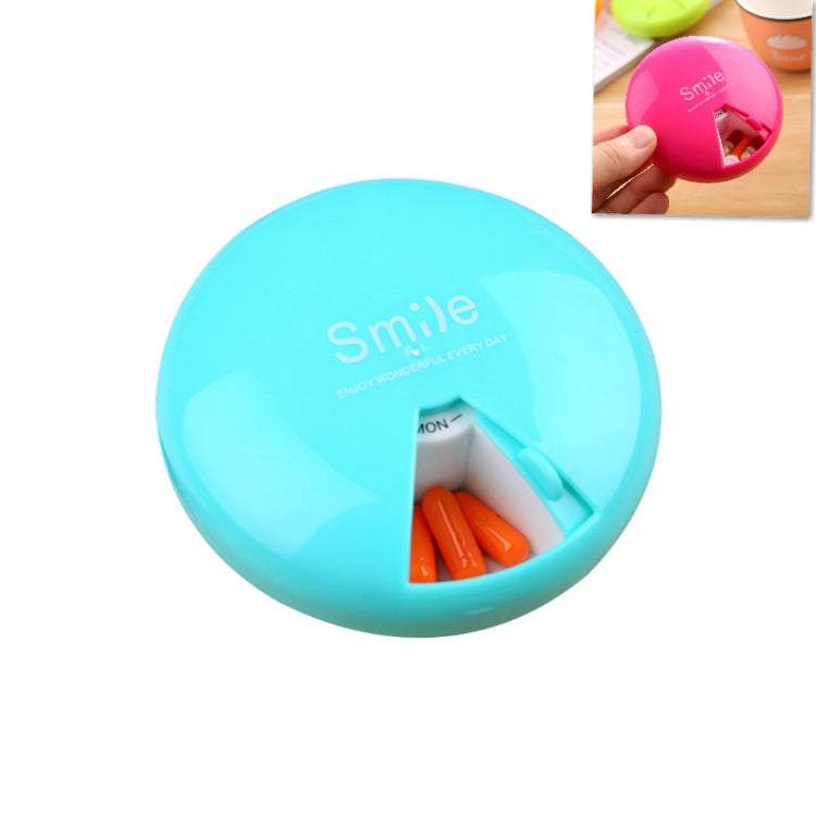 Blue 7-day rotating pill container with open pill slot and capsules inside
